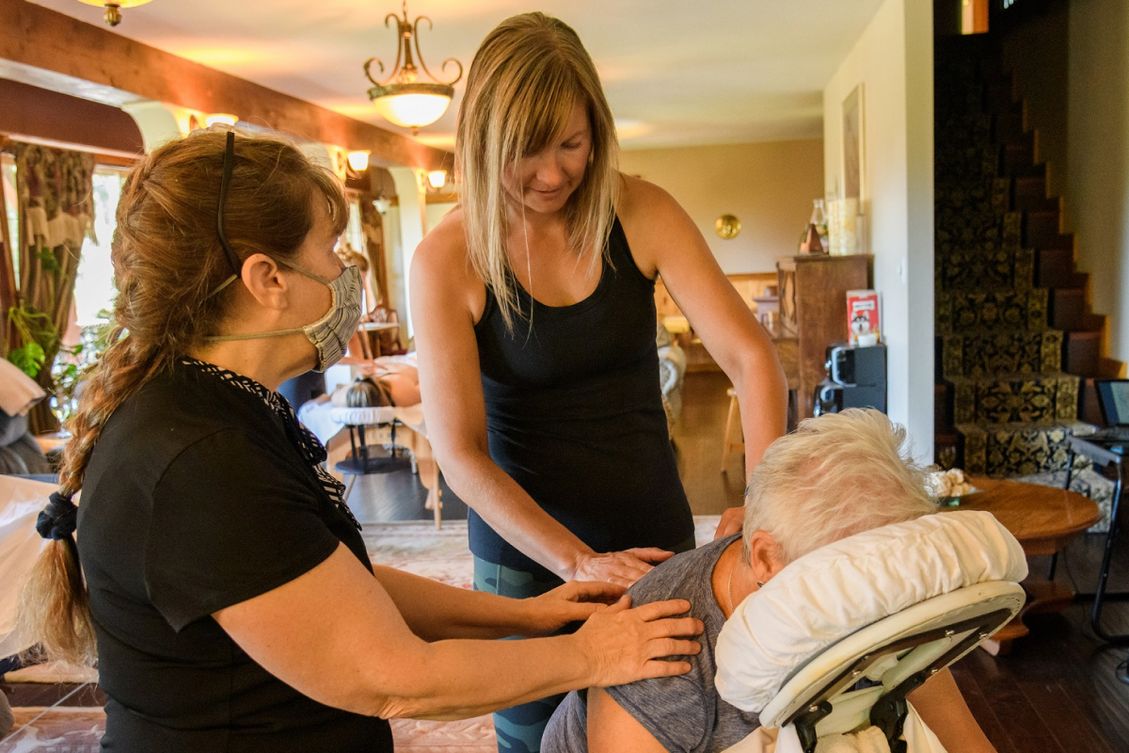 Jocelyn helping a therapist and patient in a massage session